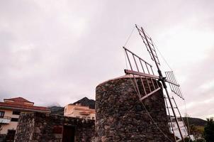 Traditional windmill under cloudy sky photo