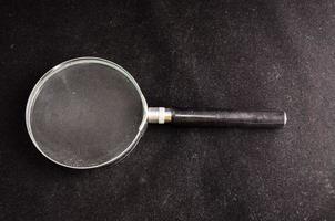 Magnifying glass on black background photo