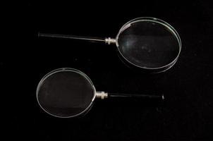 Magnifying glasses on black background photo