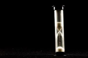 Hourglass on black background photo