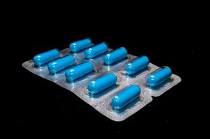 Blue pills on black background photo