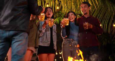 Footage of Happy Asian friends having dinner party together - Young people toasting beer glasses dinner outdoor  - People, food, drink lifestyle, new year celebration concept. video