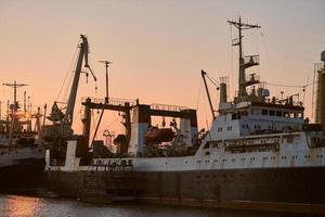 Ships in sea port on sunset background photo