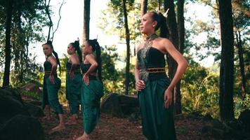 uma mulher asiática em um vestido verde se aproximou de um homem quando ele estava saindo com sua namorada no meio da floresta video