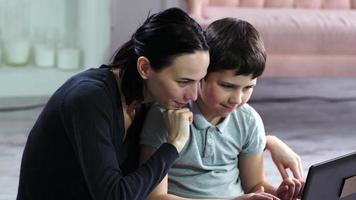 Mother and her son working up on laptop.European people. video