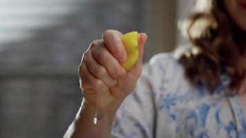 vrouw knijpt citroen door hand- video