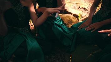 A Hands of an Asian woman while laughing and sitting together inside the forest while meeting together with their friends near the village video