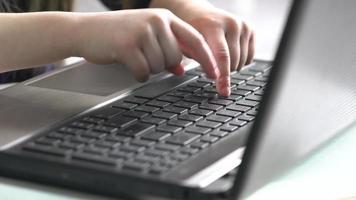 Hands of child on computer keyboard. Close up video