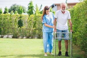 caregiver helping senior caucasian man to walk photo