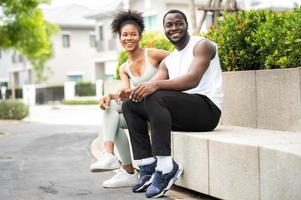 feliz sonriente pareja afroamericana sentada al aire libre foto