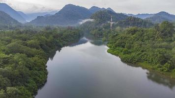 hermoso paisaje natural del río del bosque tropical con verdes colinas y árboles en el fondo. foto