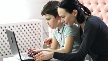 Mother and her son working up on laptop.European people. video