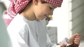 Little arabic boy unpacking gift at home. video