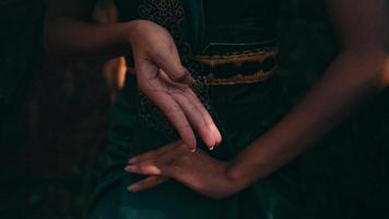The hand of an Asian woman in a green dress while doing meditation video