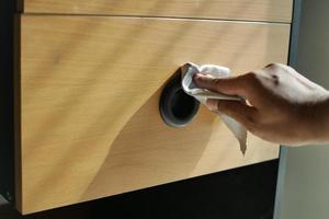 person hand cleaning drawer with a tissue photo