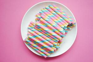 colorful wafer roll chocolate on pink background photo