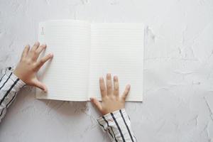 vista superior de la mano del niño girando un buscapersonas de un diario foto