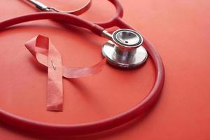 Red ribbon HIV, and stethoscope on white background. photo