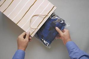 men taking a cloth out from a shopping bag photo