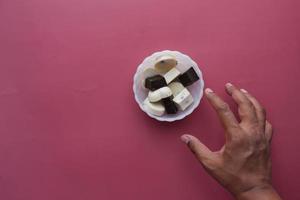 hand reach for dark chocolate on a plate photo