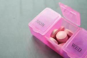 close up of medical pills in a pill box on table photo