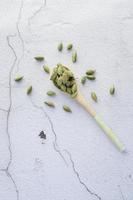 close up of Cardamom on a spoon on table photo