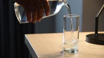 gesundes mineralwasser, das auf holztisch in das glas gießt video