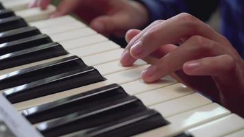 close-up dos dedos de um menino aprendendo a tocar piano. video