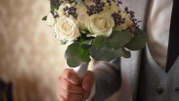 wedding bouquet in the hands of the groom video