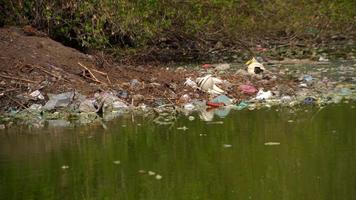 bouteilles et sacs en plastique pollution dans l'étang. video