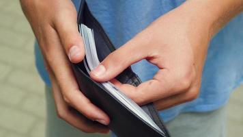een Mens looks Bij een portemonnee vol van bankbiljetten video