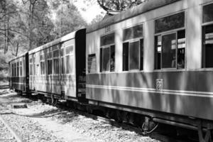 tren de juguete moviéndose en la ladera de la montaña, hermosa vista, una montaña lateral, un valle lateral moviéndose en ferrocarril hacia la colina, entre bosques naturales verdes. tren de juguete de kalka a shimla en india foto