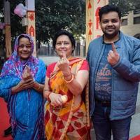 New Delhi, India - December 04 2022 - Unidentified people showing their ink-marked fingers after casting votes in front of polling booth of east Delhi area for MCD local body Elections 2022 photo