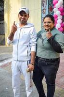 New Delhi, India - December 04 2022 - Unidentified people showing their ink-marked fingers after casting votes in front of polling booth of east Delhi area for MCD local body Elections 2022 photo