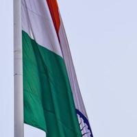 India flag flying high at Connaught Place with pride in blue sky, India flag fluttering, Indian Flag on Independence Day and Republic Day of India, tilt up shot, Waving Indian flag, Har Ghar Tiranga photo