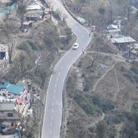 Aerial top view of traffic vehicles driving at mountains roads at Nainital, Uttarakhand, India, View from the top side of mountain for movement of traffic vehicles photo