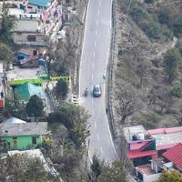 Aerial top view of traffic vehicles driving at mountains roads at Nainital, Uttarakhand, India, View from the top side of mountain for movement of traffic vehicles photo