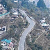 Aerial top view of traffic vehicles driving at mountains roads at Nainital, Uttarakhand, India, View from the top side of mountain for movement of traffic vehicles photo