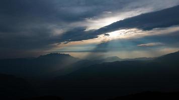 paisaje de montaña con rayos de sol atravesando las nubes foto