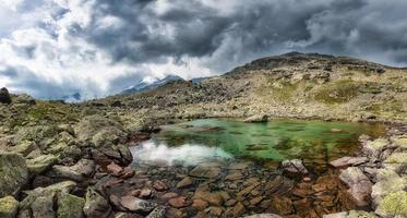 Small high mountain lake with transparent photo