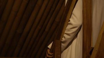 hommes musulmans dans les escaliers de sa maison en bambou tout en portant des vêtements blancs video