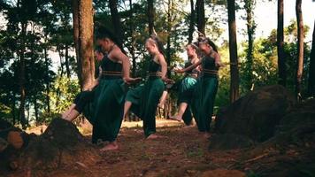 A Group of Balinese women dancing together in traditional green costumes near the tree inside the forest video