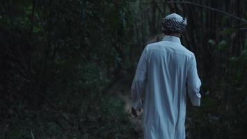 A Muslim with Arabian white clothes walking in the forest in the morning video