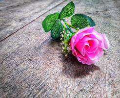 las rosas rosadas en una mesa de madera se ven hermosas, adecuadas para tarjetas o invitaciones foto