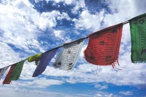 banderas de oración tibetanas en el cielo azul con nubes foto