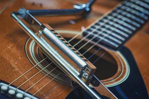 armónica de boca descansando sobre guitarra acústica foto