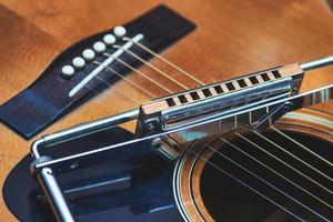 Blues harmonica resting on guitar photo