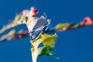 Colorful Tibetan Buddhist prayer flags waving in the wind on blu photo
