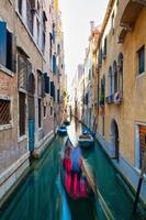 Blurred effect for a gondolier with tourists in a canal in Venice photo