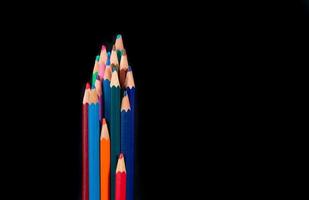 Group of colored wooden pencils on black backgroun photo